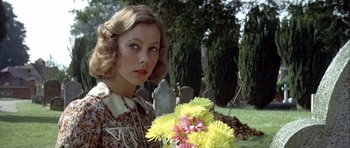 Movie still from “The Eagle Has Landed” (1976), directed by John Sturges – A woman holding a bouquet of flowers in a cemetery; Close Up shot, Low angle