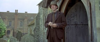Movie still from “The Eagle Has Landed” (1976), directed by John Sturges – A man standing in front of an old building; Medium shot, Low angle
