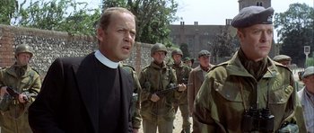 Movie still from “The Eagle Has Landed” (1976), directed by John Sturges – A group of men standing next to each other in uniforms; Medium shot, Over the shoulder angle