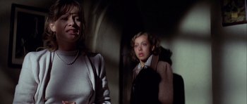 Movie still from “The Eagle Has Landed” (1976), directed by John Sturges – Two women are standing next to each other in a dark room; Close Up shot, Over the shoulder angle