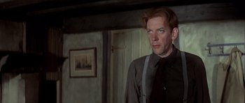 Movie still from “The Eagle Has Landed” (1976), directed by John Sturges – A man standing in front of a mirror in a room; Close Up shot, Low angle