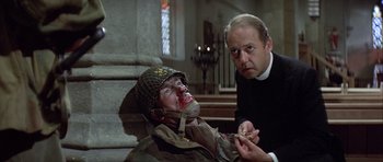 Movie still from “The Eagle Has Landed” (1976), directed by John Sturges – A man holding a knife next to a man in a uniform; Close Up shot, Low angle