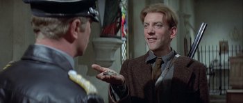 Movie still from “The Eagle Has Landed” (1976), directed by John Sturges – A man in a suit and tie talking to a man in a uniform; Close Up shot, Low angle