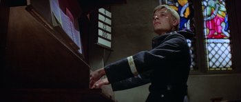 Movie still from “The Eagle Has Landed” (1976), directed by John Sturges – A man in a uniform playing an arcade game; Close Up shot, Low angle