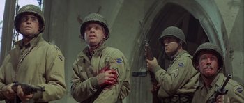 Movie still from “The Eagle Has Landed” (1976), directed by John Sturges – Two men dressed in military uniforms and one has a gunshot wound to his arm; Medium shot, Low angle
