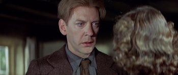 Movie still from “The Eagle Has Landed” (1976), directed by John Sturges – A person wearing a suit and a tie; Close Up shot, Over the shoulder angle