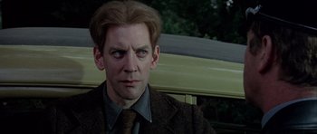 Movie still from “The Eagle Has Landed” (1976), directed by John Sturges – A person wearing a suit and tie; Close Up shot, Over the shoulder angle