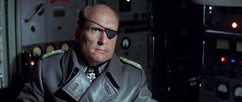 Movie still from “The Eagle Has Landed” (1976), directed by John Sturges – An older man wearing a leather jacket and a pirate eye patch; Close Up shot, Low angle