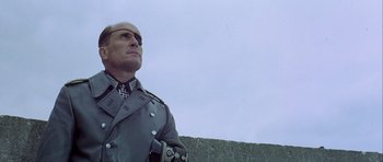 Movie still from “The Eagle Has Landed” (1976), directed by John Sturges – A man in a military uniform looking into the sky; Close Up shot, Low angle