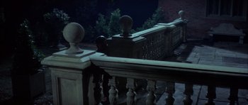 Movie still from “The Eagle Has Landed” (1976), directed by John Sturges – A view of a railing from a balcony at night time; Wide shot, High angle