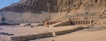 Movie still from “The Egyptian” (1954), directed by Michael Curtiz – A group of people standing on top of a sandy beach next to a building; Extreme Wide shot, High angle