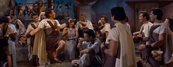 Movie still from “The Egyptian” (1954), directed by Michael Curtiz – A group of men and women gathered in a room; Wide shot, High angle