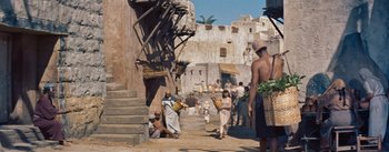 Movie still from “The Egyptian” (1954), directed by Michael Curtiz – A group of people walking down a street; Wide shot, High angle