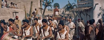 Movie still from “The Egyptian” (1954), directed by Michael Curtiz – A group of men in ancient egyptian garb in a parade; Wide shot, High angle