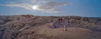 Movie still from “The Egyptian” (1954), directed by Michael Curtiz – A man standing on a hill in the middle of the desert; Extreme Wide shot, High angle