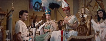 Movie still from “The Egyptian” (1954), directed by Michael Curtiz – A couple of people that are dressed up in costumes; Medium shot, Low angle