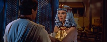 Movie still from “The Egyptian” (1954), directed by Michael Curtiz – A woman in a costume is talking to a man in a robe; Close Up shot, Over the shoulder angle