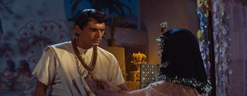 Movie still from “The Egyptian” (1954), directed by Michael Curtiz – A man and a woman are standing in front of each other; Medium shot, Over the shoulder angle