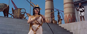 Movie still from “The Egyptian” (1954), directed by Michael Curtiz – A woman dressed as cleopatra holding a bow and arrow; Medium shot, Low angle