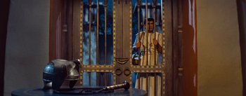 Movie still from “The Egyptian” (1954), directed by Michael Curtiz – A man standing behind bars in a jail cell; Medium shot, Low angle