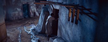 Movie still from “The Egyptian” (1954), directed by Michael Curtiz – A man standing in front of an old building; Wide shot, High angle