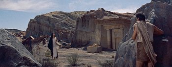Movie still from “The Egyptian” (1954), directed by Michael Curtiz – A woman standing in front of an ancient building; Extreme Wide shot, High angle