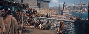 Movie still from “The Egyptian” (1954), directed by Michael Curtiz – A group of men sitting next to each other on the ground; Wide shot, High angle