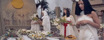 Movie still from “The Egyptian” (1954), directed by Michael Curtiz – A group of women dressed in white and holding flowers; Medium shot, High angle