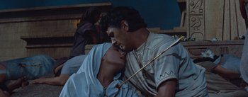 Movie still from “The Egyptian” (1954), directed by Michael Curtiz – A man and a woman kissing each other in front of an audience; Close Up shot, Low angle