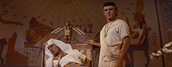 Movie still from “The Egyptian” (1954), directed by Michael Curtiz – A man standing next to an egyptian pharaoh; Medium shot, Low angle