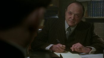 Movie still from “The End of the Affair” (1999), directed by Neil Jordan – A man in a suit and tie writing on a piece of paper; Close Up shot, Over the shoulder angle