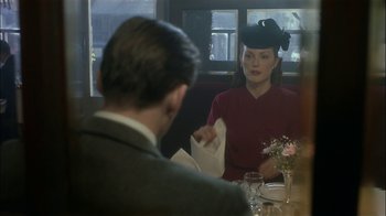 Movie still from “The End of the Affair” (1999), directed by Neil Jordan – A man and a woman sitting at a table in a restaurant; Medium shot, Over the shoulder angle