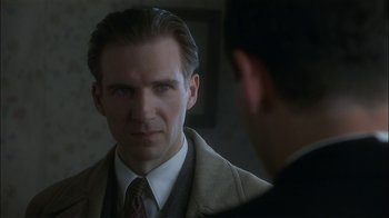 Movie still from “The End of the Affair” (1999), directed by Neil Jordan – A person wearing a suit and tie; Close Up shot, Over the shoulder angle