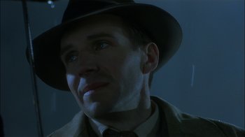 Movie still from “The End of the Affair” (1999), directed by Neil Jordan – A person wearing a hat and a suit; Close Up shot, Low angle
