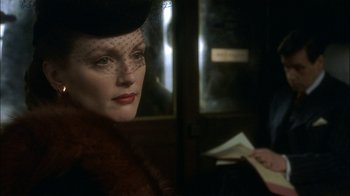 Movie still from “The End of the Affair” (1999), directed by Neil Jordan – A woman in a hat and a fur coat looking to her left; Close Up shot, Over the shoulder angle