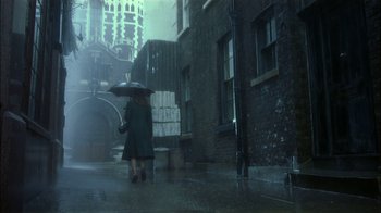 Movie still from “The End of the Affair” (1999), directed by Neil Jordan – A woman walking down the street holding an umbrella; Wide shot, Low angle