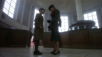 Movie still from “The End of the Affair” (1999), directed by Neil Jordan – Two women are standing in a court room talking to each other; Wide shot, Low angle