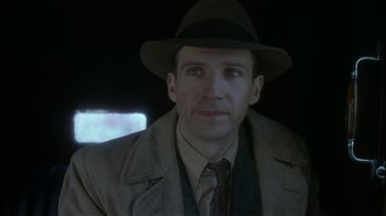 Movie still from “The End of the Affair” (1999), directed by Neil Jordan – A person wearing a hat and a coat; Close Up shot, Over the shoulder angle