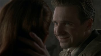 Movie still from “The End of the Affair” (1999), directed by Neil Jordan – A person smiling at the camera; Close Up shot, Over the shoulder angle