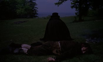 Movie still from “The Enigma of Kaspar Hauser” (1974), directed by Werner Herzog – Two people lying on the ground in the dark; Wide shot, High angle