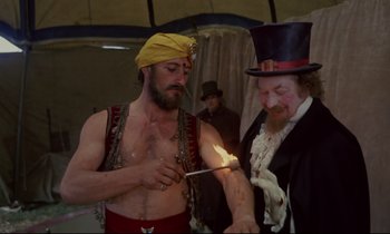 Movie still from “The Enigma of Kaspar Hauser” (1974), directed by Werner Herzog – A man lighting a match with a stick; Medium shot, Over the shoulder angle