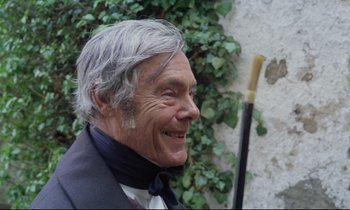 Movie still from “The Enigma of Kaspar Hauser” (1974), directed by Werner Herzog – An older man with a cane in front of a wall; Close Up shot, Over the shoulder angle