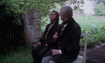 Movie still from “The Enigma of Kaspar Hauser” (1974), directed by Werner Herzog – Two people sitting on a bench in a park; Medium shot, Over the shoulder angle