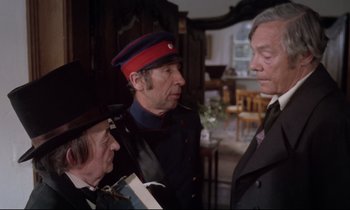 Movie still from “The Enigma of Kaspar Hauser” (1974), directed by Werner Herzog – A group of men standing next to each other in a room; Medium shot, Over the shoulder angle