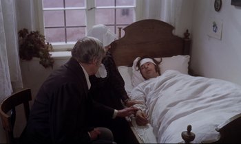 Movie still from “The Enigma of Kaspar Hauser” (1974), directed by Werner Herzog – An older man and woman in a bed with a woman in a bed; Medium shot, High angle