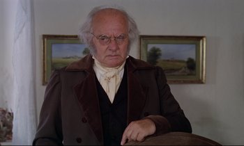 Movie still from “The Enigma of Kaspar Hauser” (1974), directed by Werner Herzog – An old man in a brown coat and a white beard; Close Up shot, Low angle