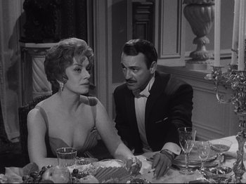 Movie still from “The Exterminating Angel” (1962), directed by Luis Buñuel – A man and a woman sitting at a dinner table; Medium shot, High angle