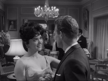 Movie still from “The Exterminating Angel” (1962), directed by Luis Buñuel – A man and a woman dancing in front of a chandelier; Medium shot, Low angle