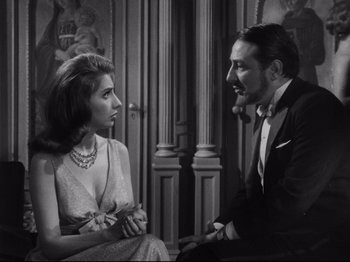 Movie still from “The Exterminating Angel” (1962), directed by Luis Buñuel – A man and a woman sitting in front of each other; Medium shot, Over the shoulder angle