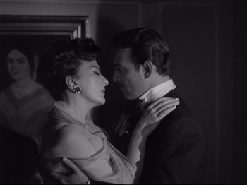 Movie still from “The Exterminating Angel” (1962), directed by Luis Buñuel – A man and a woman are kissing in a dark room; Close Up shot, Low angle